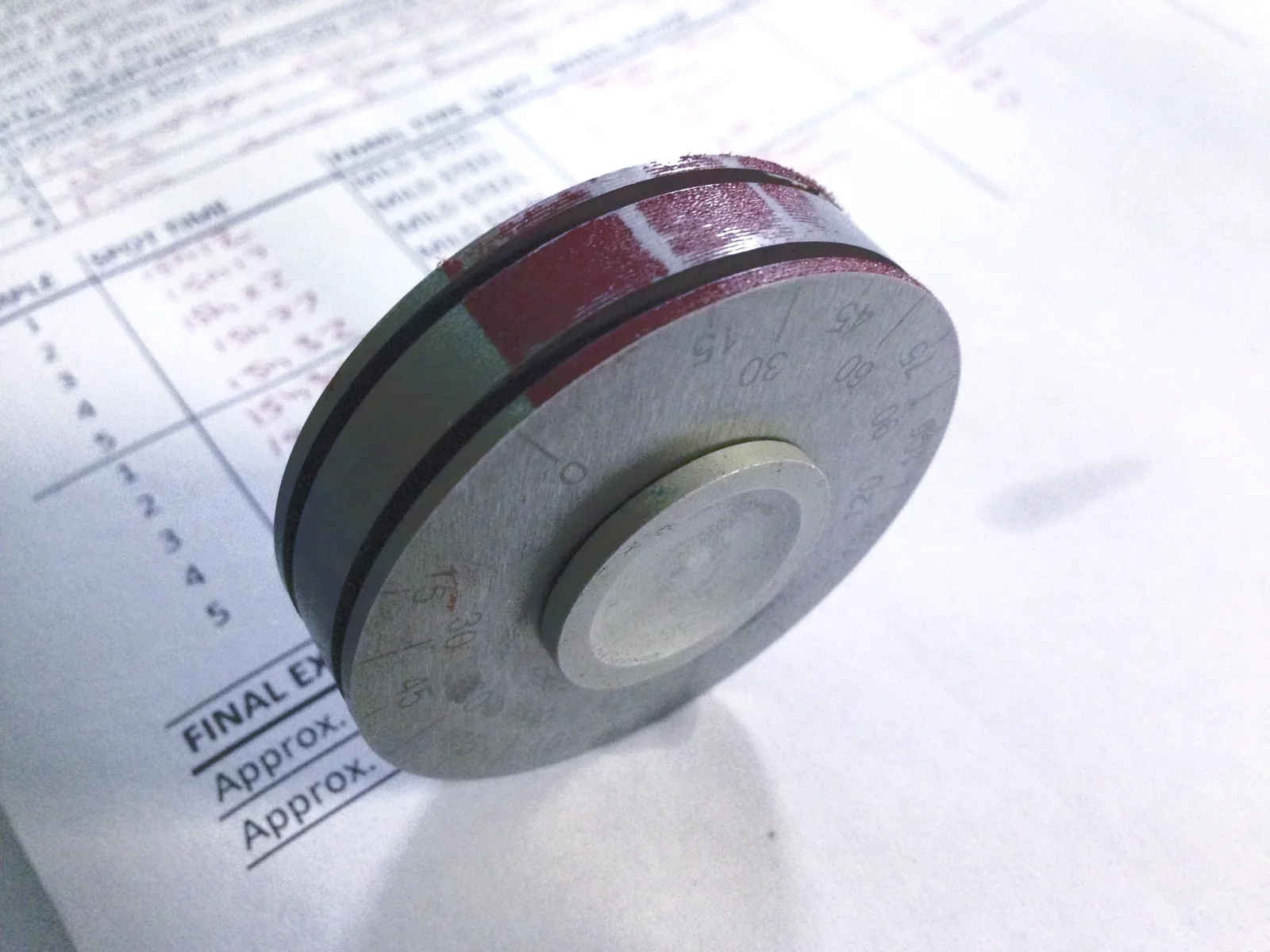A wet-film thickness gauge on a completed Marindec quality-control record